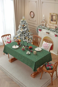 Detail of green Christmas tablecloth with gold snowflake patterns on a holiday dinner table