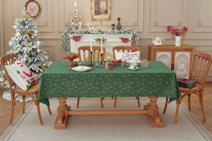 Detail of dark green Christmas tablecloth with gold snowflake patterns and festive decor