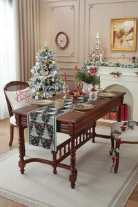 Close-up of jacquard Christmas table runner with green trees and festive cushions