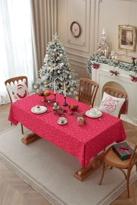 Detail of red Christmas tablecloth with golden snowflakes and deer print on a dining table