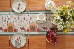 Detail of Ramadan table runner with woven mosque and moon patterns on a wooden table