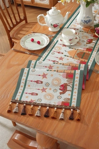 Close-up of jacquard table runner with moon, mosque and camel patterns and tassel trim