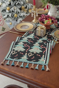 Detail of Christmas table runner with woven tree patterns and colorful fringe tassels