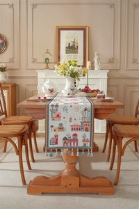 Detail of jacquard table runner with exotic city patterns and light blue tassels decoration