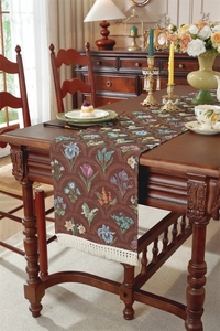 Détail d'un chemin de table vintage à fleurs avec tissage jacquard et pompons blancs
