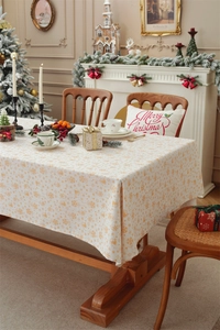 Detail of Christmas tablecloth with golden bells and snowflakes on beige cotton fabric