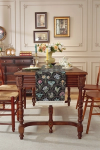 Détail du chemin de table jacquard à fleurs vintage avec bordure de franges blanches