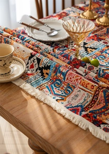 Detail of bohemian jacquard table runner with colorful floral patterns and white fringe