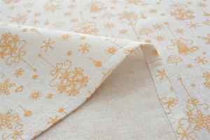 Detailed close-up of festive golden bells and snowflake prints on poly-cotton table runner