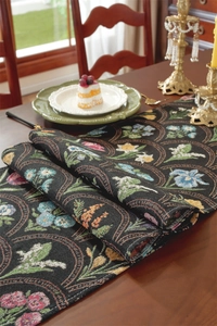 Détail d'un chemin de table vintage en jacquard noir avec broderies de fleurs colorées