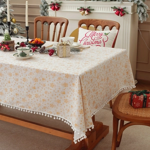 Christmas tablecloth with gold bells and snowflake prints featuring white pom-pom tassels