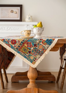 Close-up of bohemian floral tablecloth with geometric patterns and beige fringe tassels