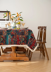 Detail of bohemian woven tablecloth featuring colorful geometric patterns and cream tassels