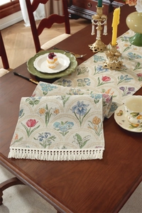 Gros plan du chemin de table vintage en jacquard fleuri avec franges sur bois