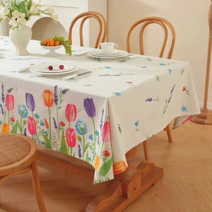 Floral tulip print rectangular tablecloth with tassels on a wooden dining table