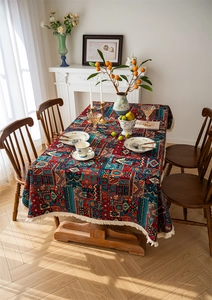 Detailed close-up of Bohemian tablecloth with floral patterns and white fringe tassels