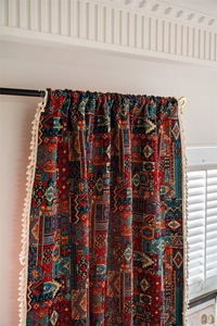 Detail of bohemian geometric pattern curtain with white cotton tassels and rod pocket