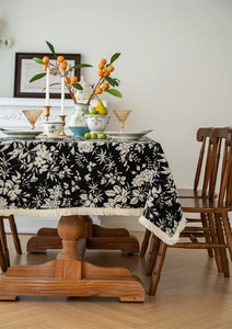 Close-up of vintage floral jacquard tablecloth with elegant cream fringe tassels