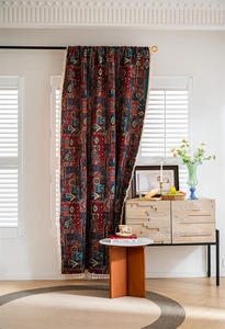 Detail of bohemian jacquard curtain featuring geometric patterns and white cotton tassels