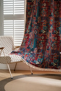 Detail of bohemian patchwork curtain with vibrant geometric patterns and white tassels