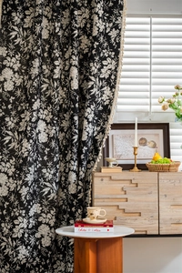 Close-up of black and white floral pattern with bohemian tassels on semi-sheer curtains