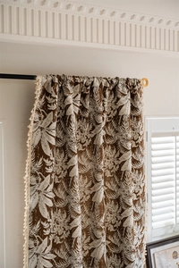 Close-up of tropical leaf jacquard curtain with elegant cream fringe tassels and linen texture