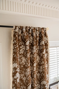 Close-up of bohemian floral jacquard curtain fabric with white tassel fringe details