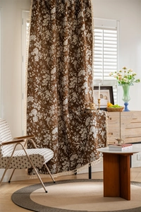 Close-up of bohemian floral curtain featuring white tassel fringe and retro brown fabric