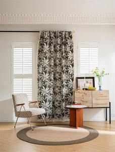 Detail of bohemian black and white tropical leaf print curtain with stylish tassel edges