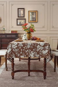 Macro detail of bohemian jacquard floral pattern on brown rectangular tablecloth