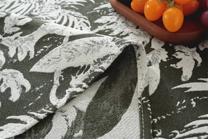 Detailed macro view of tropical leaf and bird jacquard fabric with durable hemmed edges