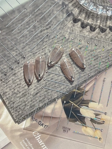 Macro view of silver starline nail stickers with rhinestones on nude pink fake nails