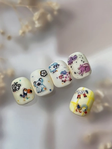 Macro shot of 3D embossed nail art featuring hand-painted cartoon animals on cream base
