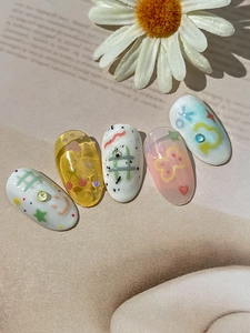 Macro detail of handmade jelly nail tips with cherry, butterfly, and 3D rhinestone accents