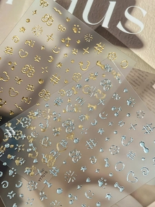 Detailed macro of 3D gold butterfly nail art stickers with various decorative patterns