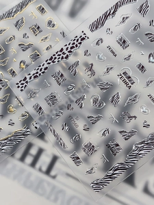 Macro shot of silver zebra and leopard pattern nail stickers with metallic foil details