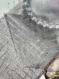 Macro shot of holographic silver laser nail stickers with minimalist linear patterns
