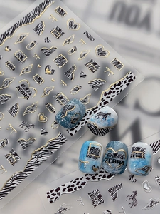 Detail of zebra pattern nail stickers with gold foil accents and butterfly heart motifs