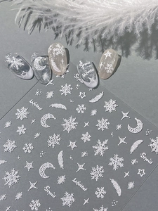 Macro view of 3D embossed snowflake and feather nail art stickers for winter manicures