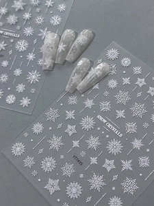 Macro detail of 3D embossed white snowflake nail decals with delicate winter patterns