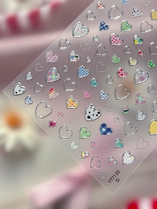 Detail showing heart-shaped nail art stickers with checkered and silver embossed textures