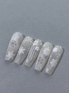 Detail of winter embossed snowflake nail art stickers with 3D texture and white pearls