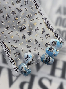 Close-up of zebra and leopard pattern nail stickers with gold foil accents on marble tips