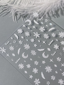 Detail of 3D embossed white snowflake and feather nail stickers on transparent film