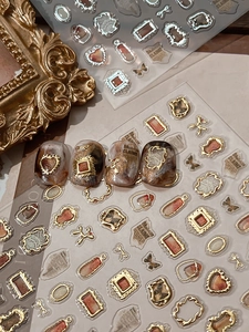 Close-up of 3D embossed nail stickers featuring vintage gold frames and heart designs