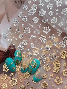 Detail of 3D gold and silver embossed cherry blossom nail stickers with floral patterns