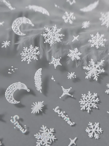 Macro shot of 3D embossed snowflake and winter nail stickers with pearlescent glitter