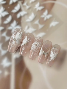 Detail of 3D embossed butterfly nail stickers with white lace and pearl accents