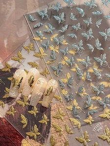 Dettaglio di adesivi per unghie farfalla 3D metallizzati con goffratura oro e argento