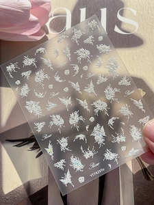 Detailed view of 3D embossed rose and butterfly nail stickers with shimmer texture